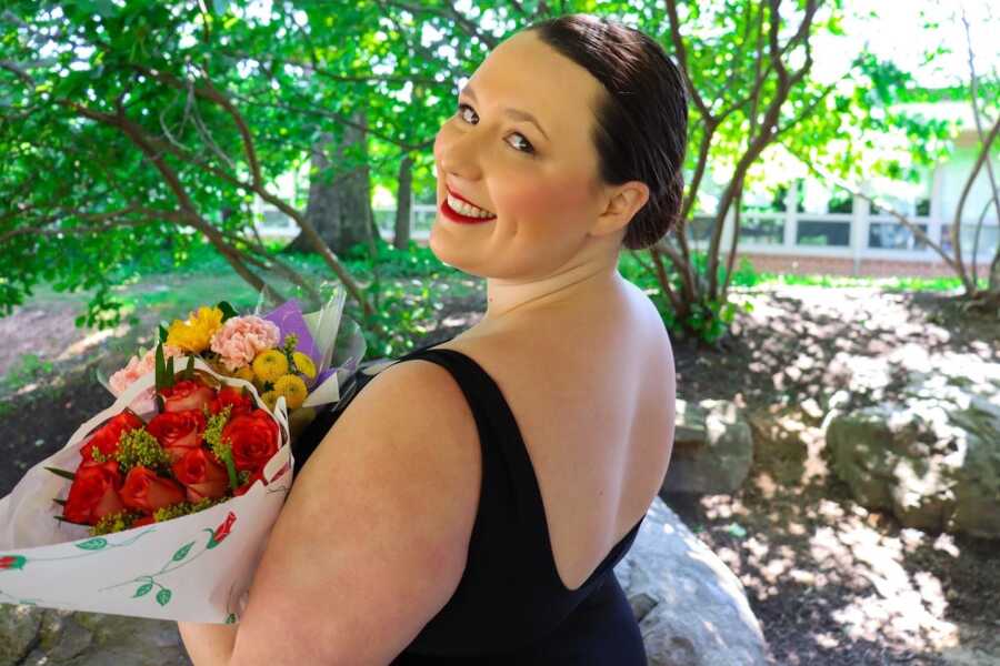 After her first recital, adult ballerina smiles with flowers