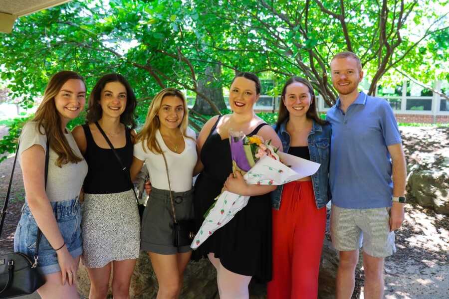 Adult ballerina and her friends pose after a recital 