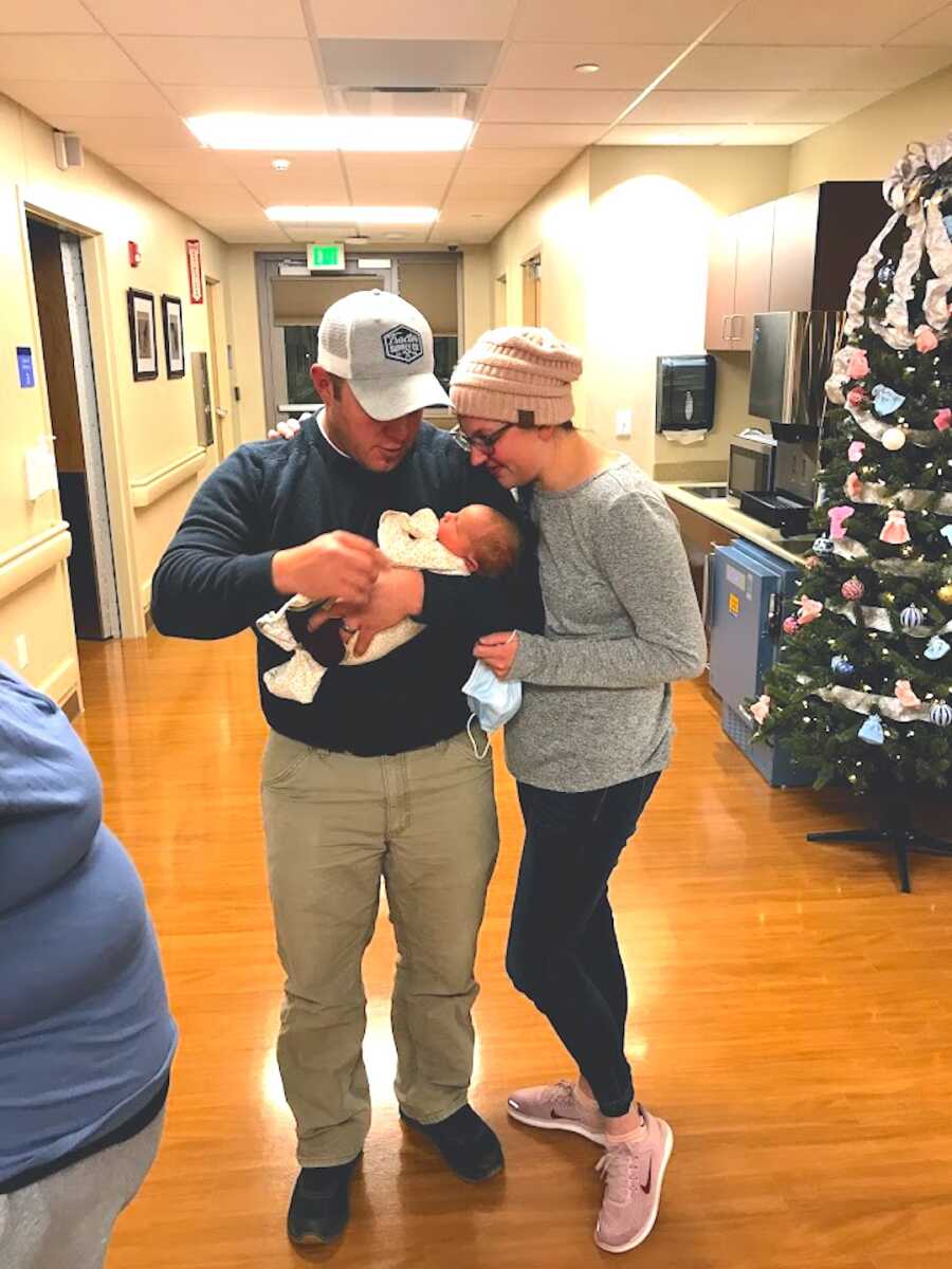 adoptive couple holds their baby girl together in the hospital