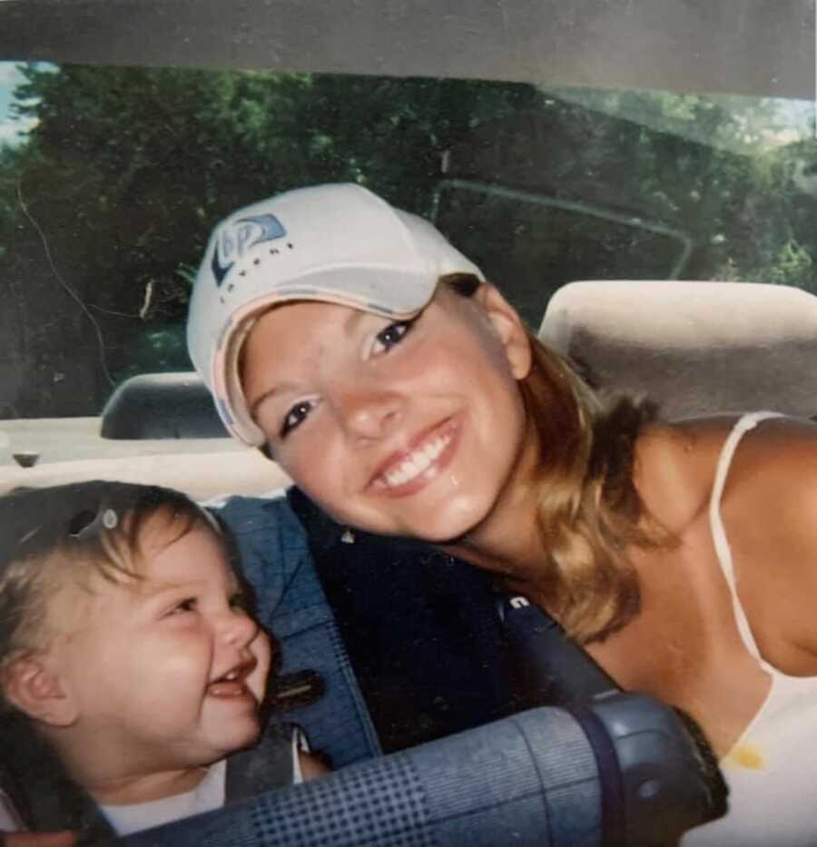 A teen mom leans in to smile with her laughing daughter