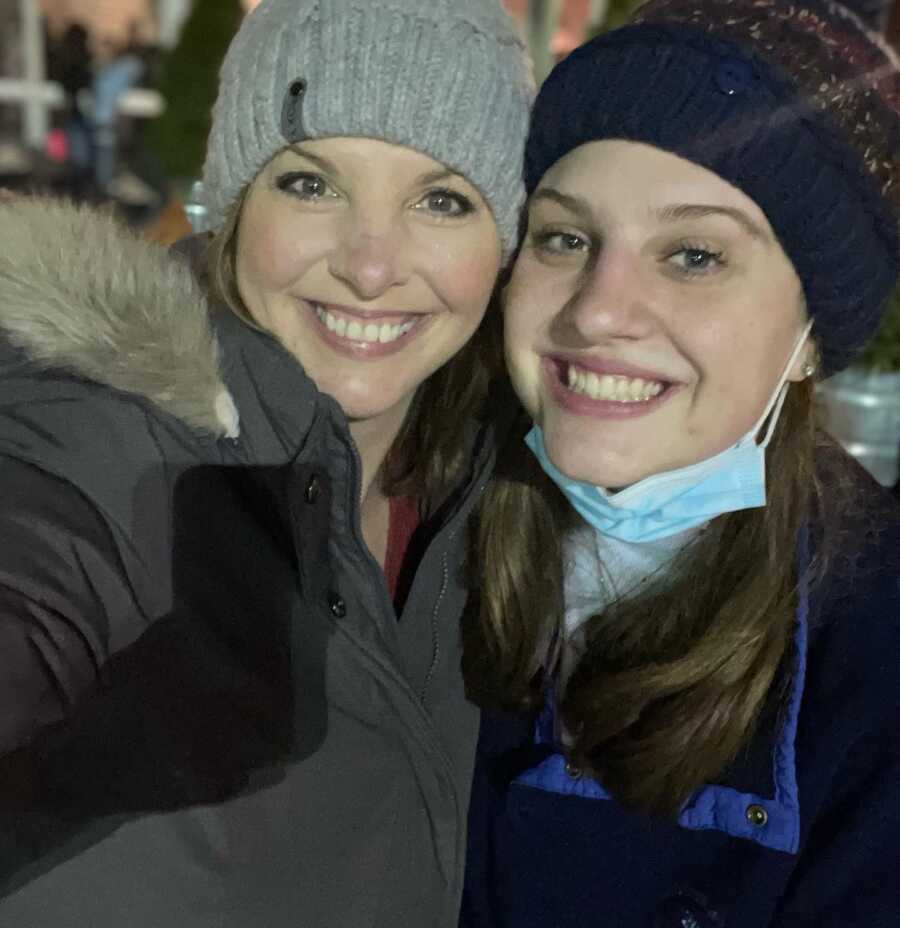 A teen mom smiles for a selfie with her teenage daughter