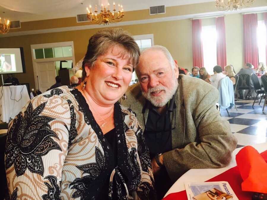 Two parents sit at a table in nice clothes