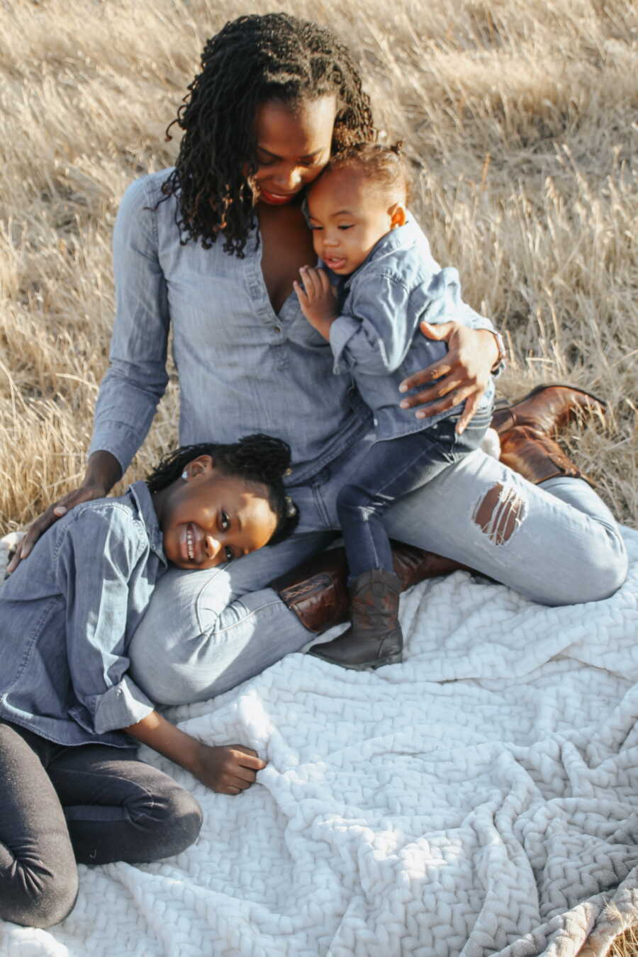 Former nurse who sued for medical malpractice sits in a field with her young children