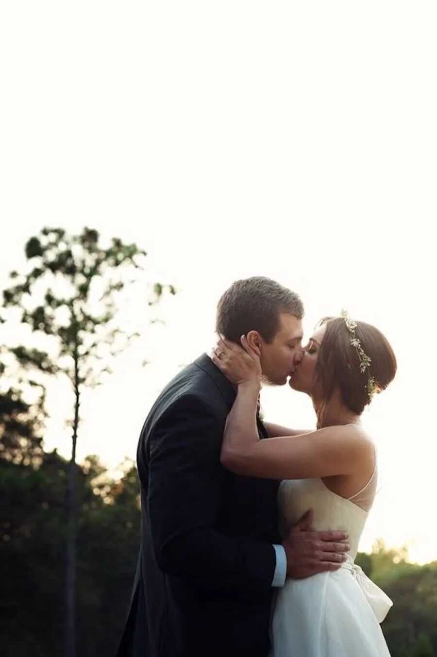 husband and wife on their wedding day kiss one another