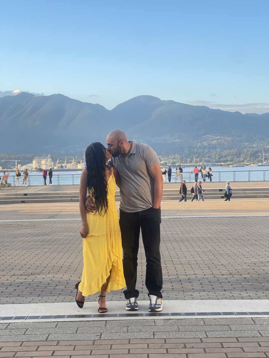 A couple kisses in a waterfront park