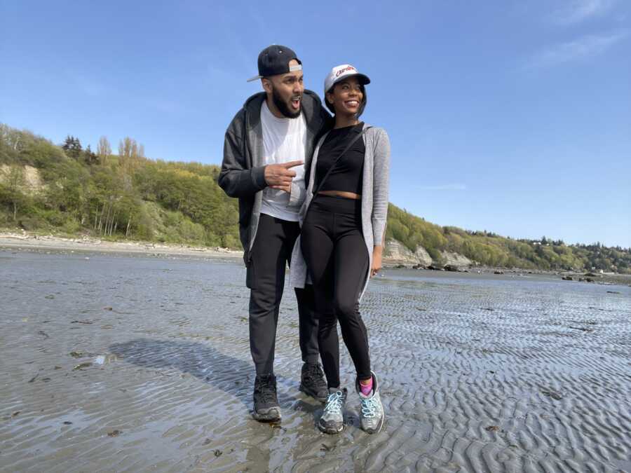 A couple stands in a natural shoreline