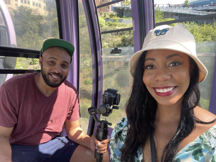 A couple sits in a gondala with film cameras 