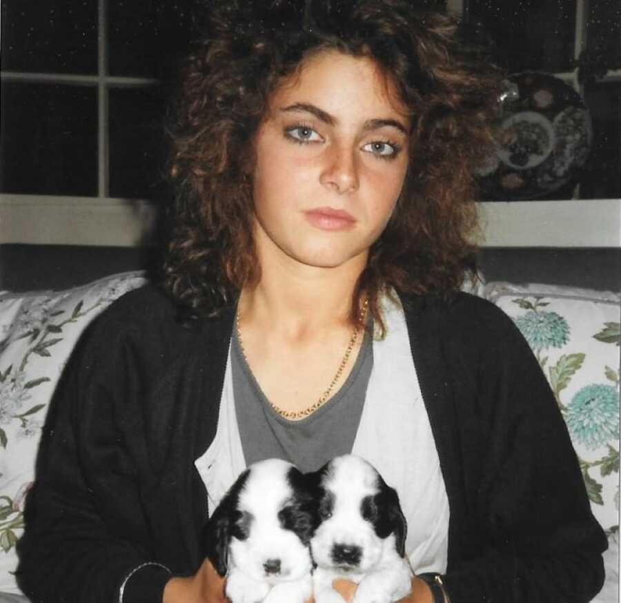 Bulimic and sexual abuse survivor woman sitting holding two puppies