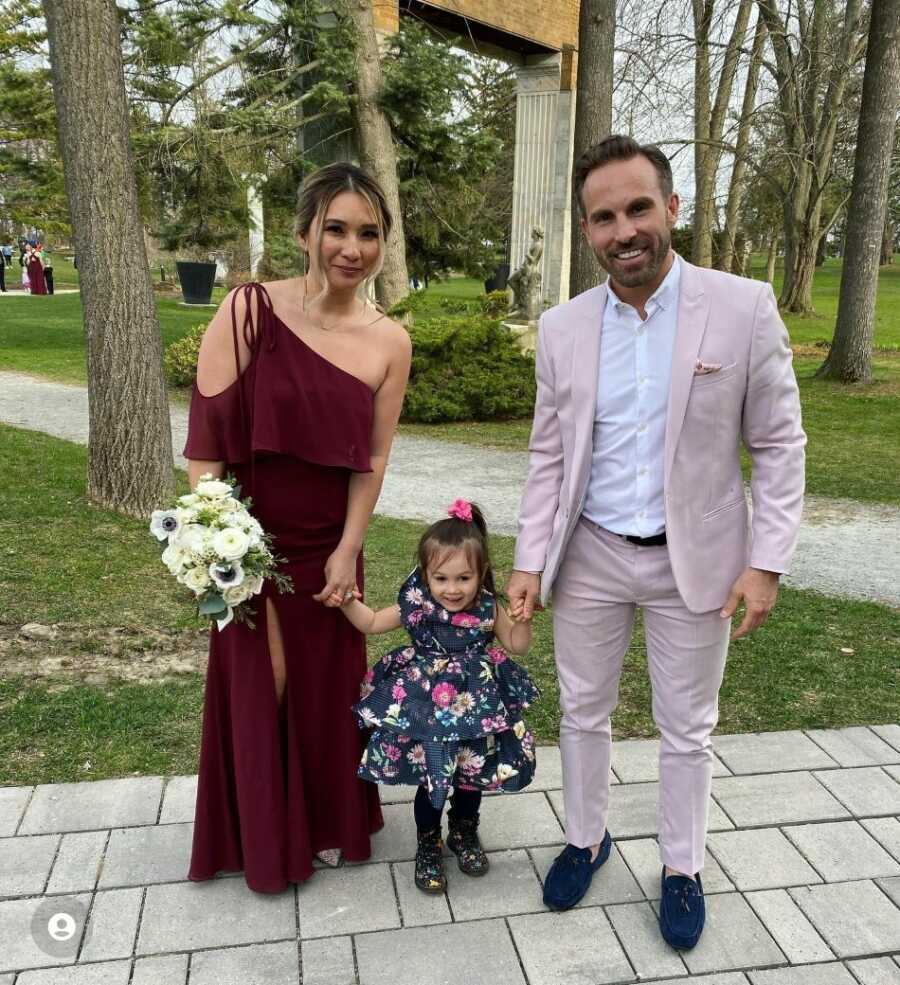 former alcoholic with wife and 2-year-old daughter in formal clothing posing for photo.