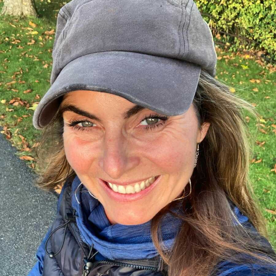 Bulimia and sexual abuse survivor taking a selfie smiling wearing grey hat