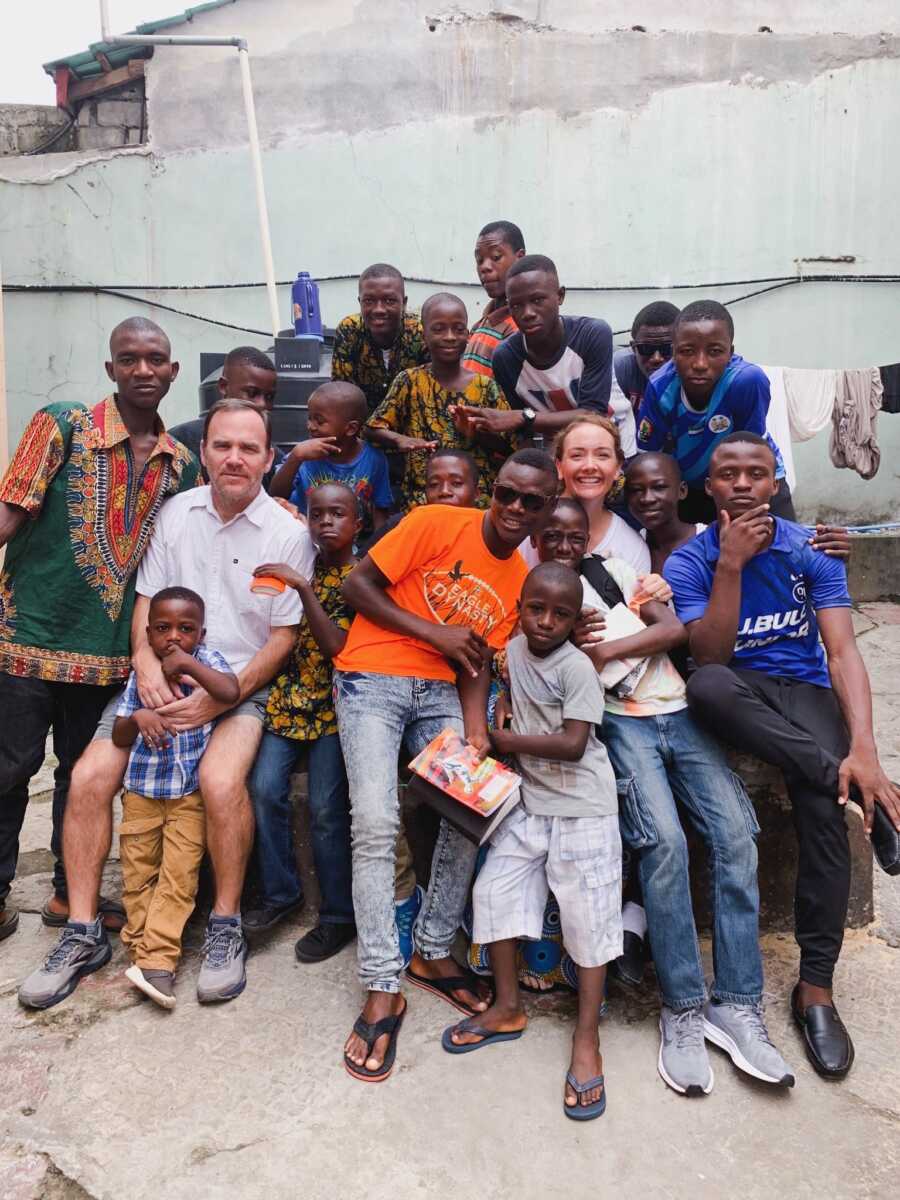couple gathered with group of many orphans in Africa