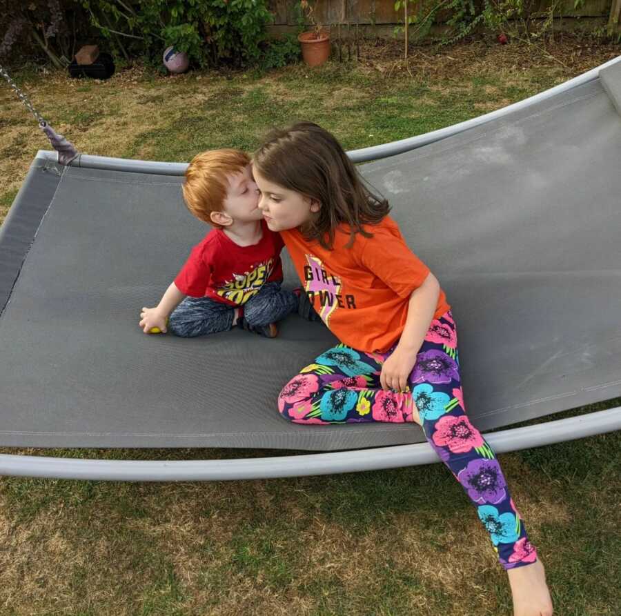 Adopted siblings kissing each others cheek