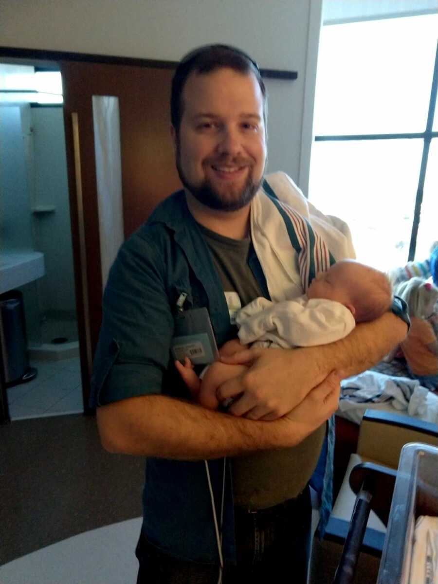 adoptive dad holding baby boy with Down Syndrome in the hospital