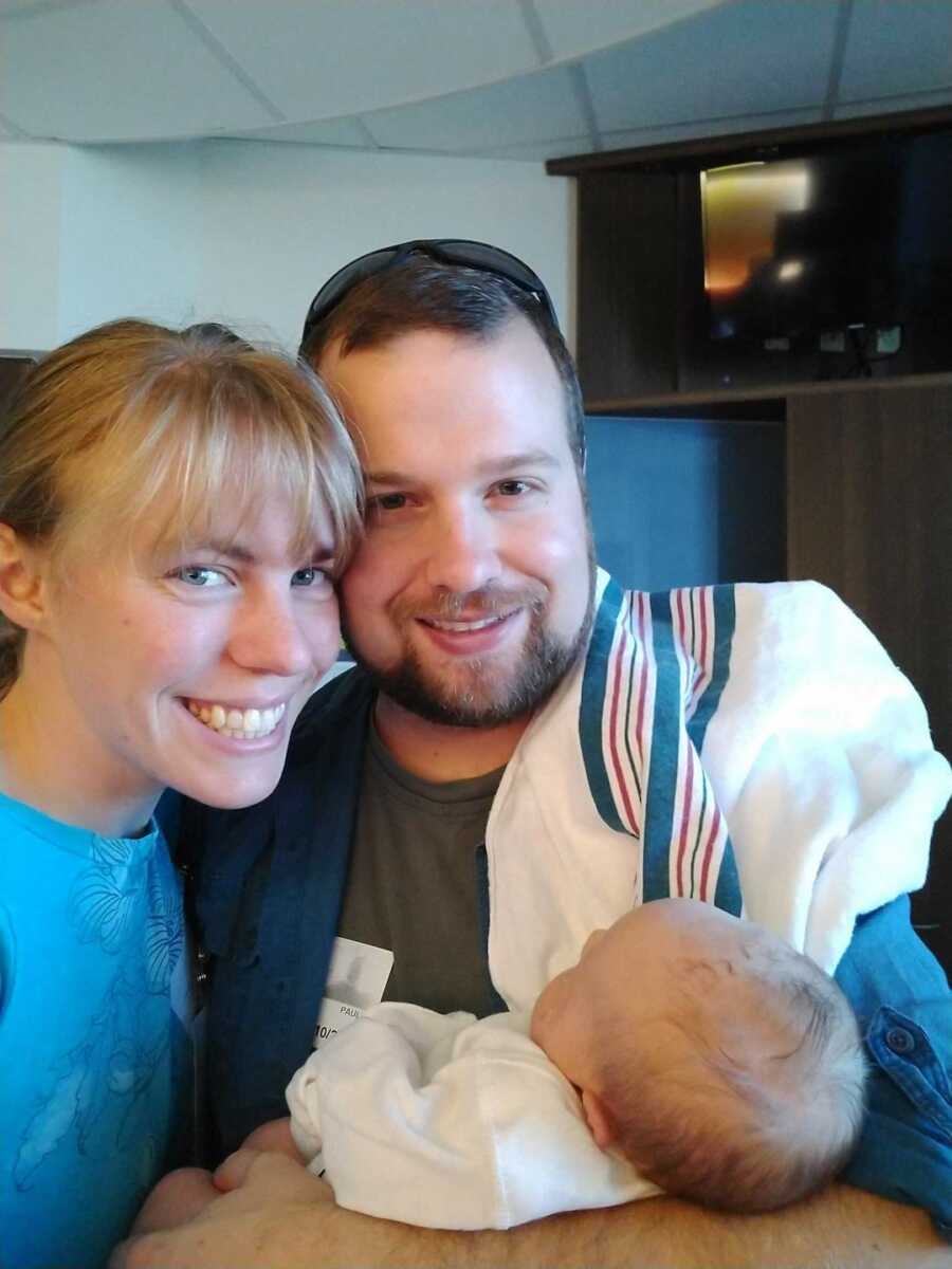 adoptive parents holding their baby boy with Down Syndrome