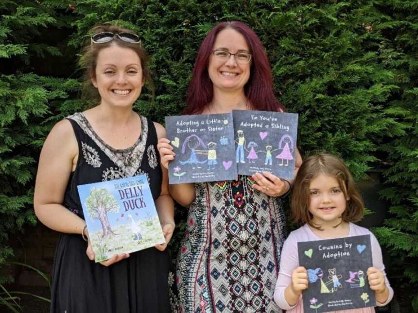 Author and family holding books in front of trees