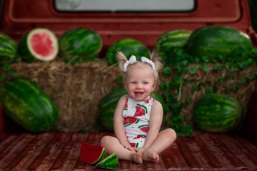 baby girl miracle twin with watermelon in bed of truck