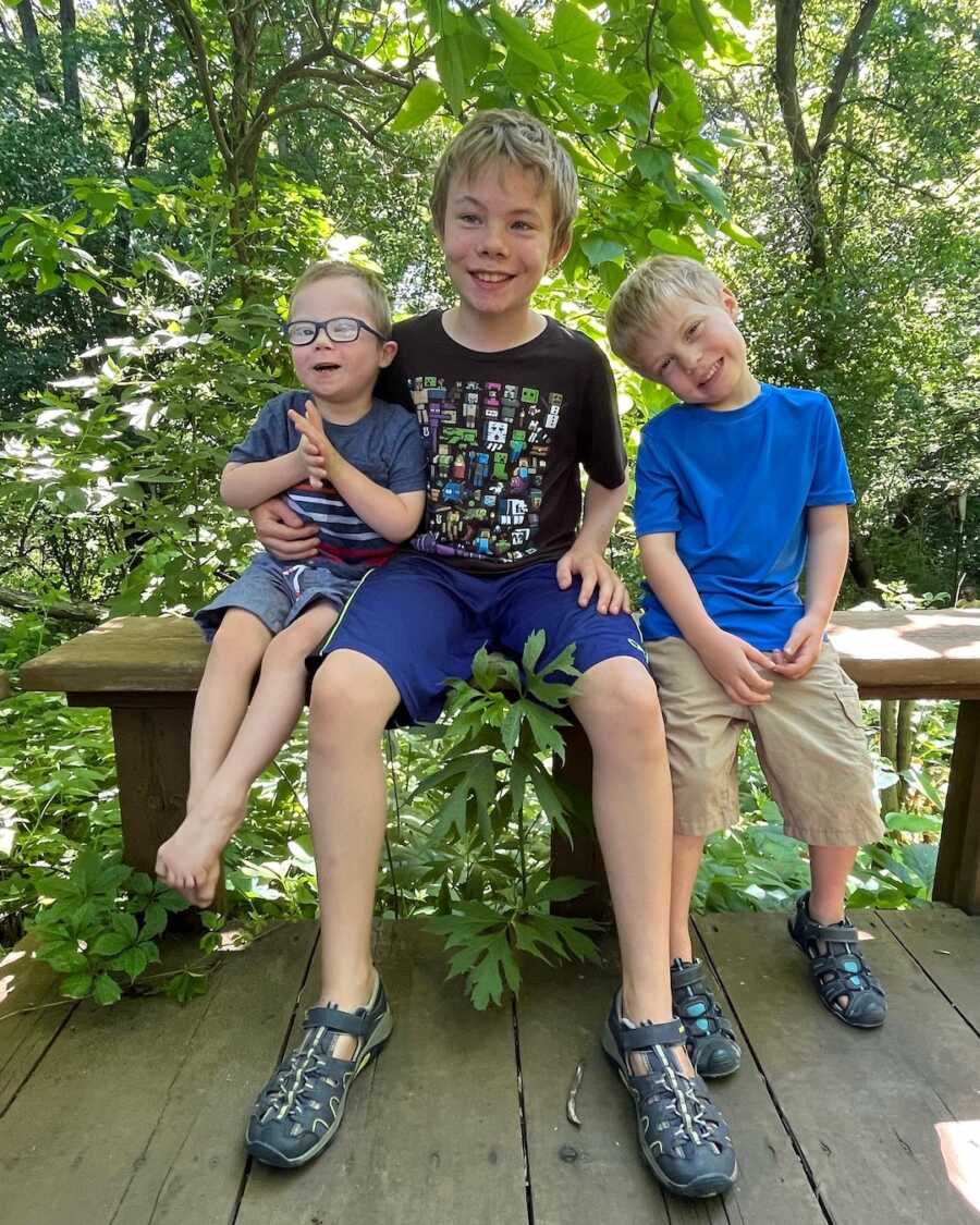 three brothers sitting together looking happy