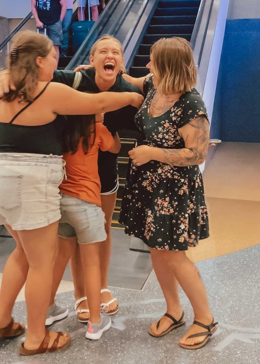 Birth mom and sisters excitedly greet daughter at the airport.