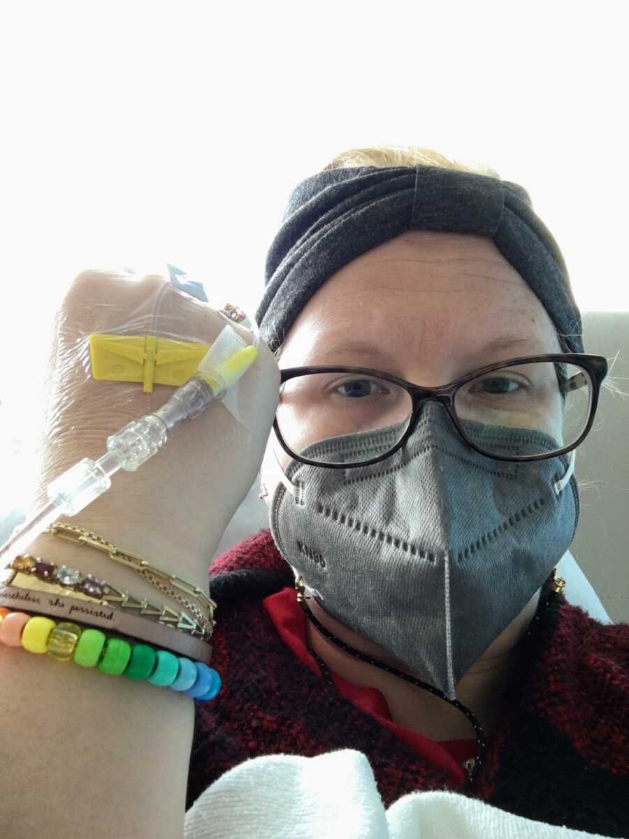 breast cancer patient wearing mask and showing medical equipment attached to hand