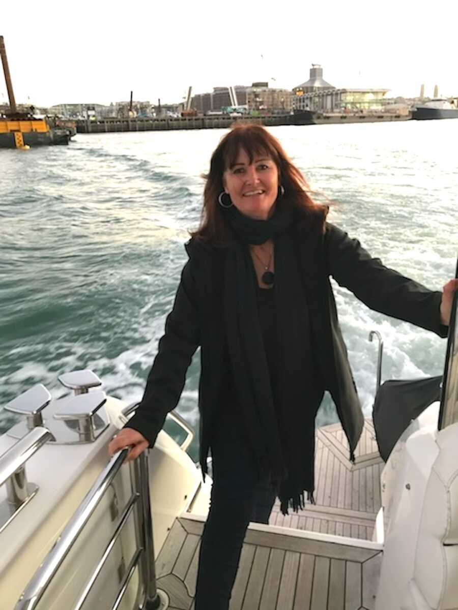 childhood sexual abuse survivor stands on a boat