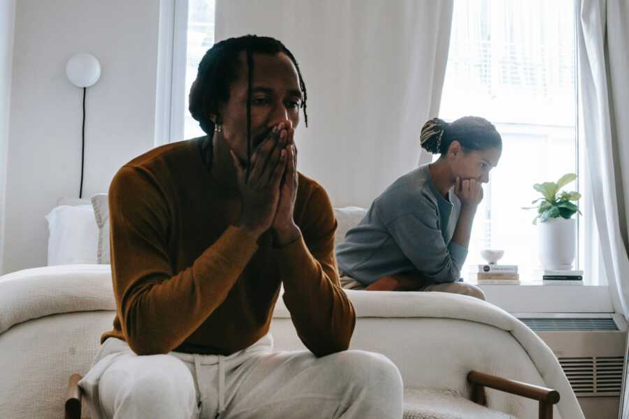 Exes arguing in bedroom with hands over faces