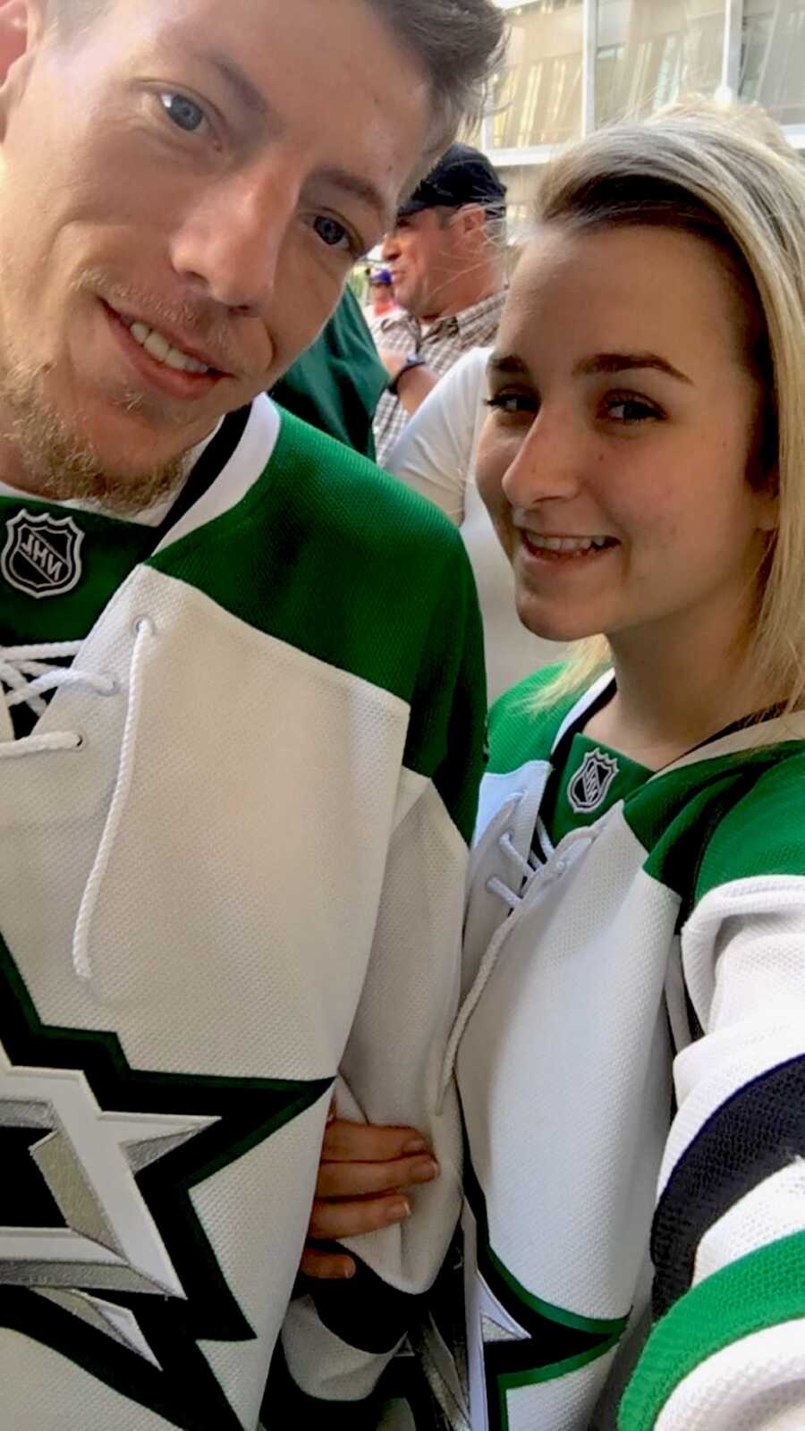 couple take a selfie wearing hockey jerseys