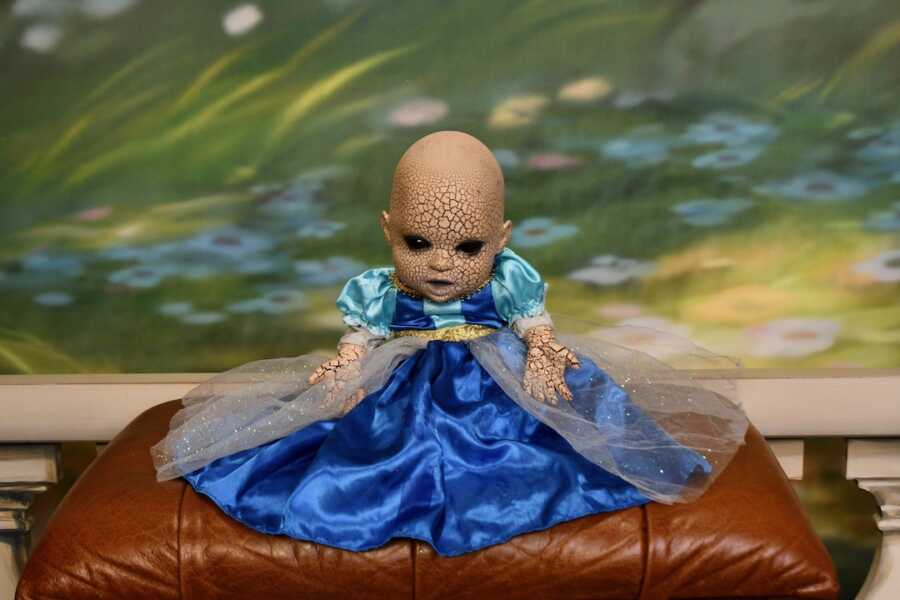 creepy halloween doll posed in princess dress
