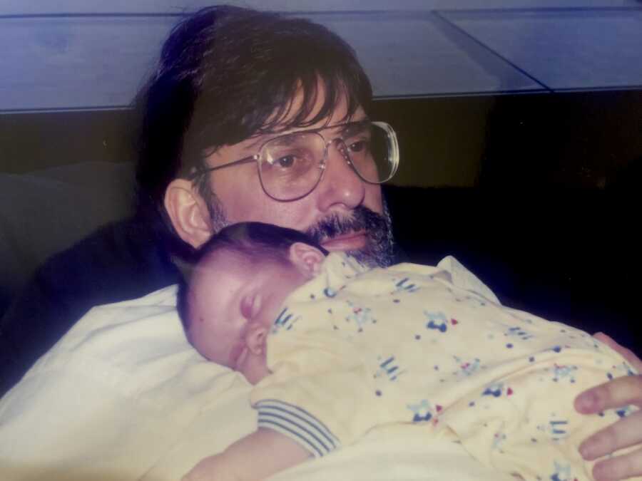 dad holds baby girl on his chest