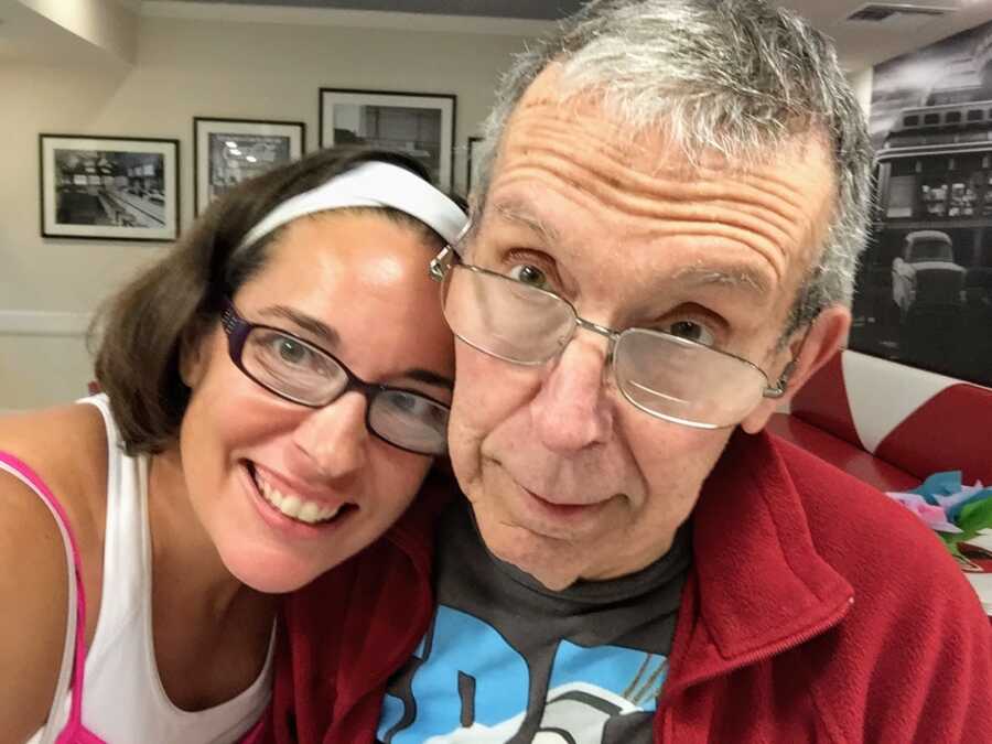 daughter smiling and leaning against Alzheimers father