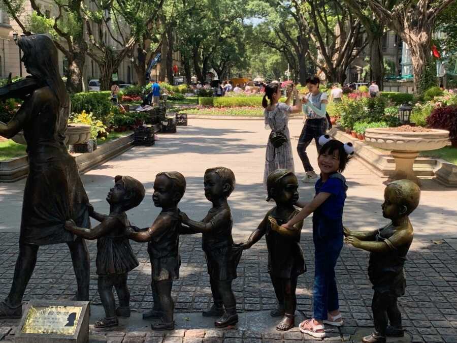 internationally adopted daughter playing with kid statues
