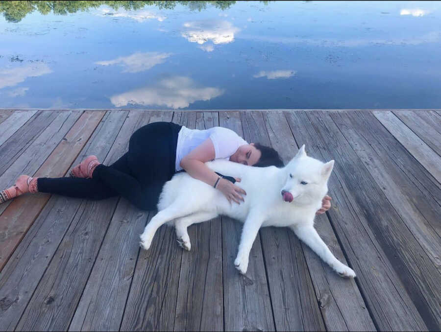 chronically ill woman laying with dog