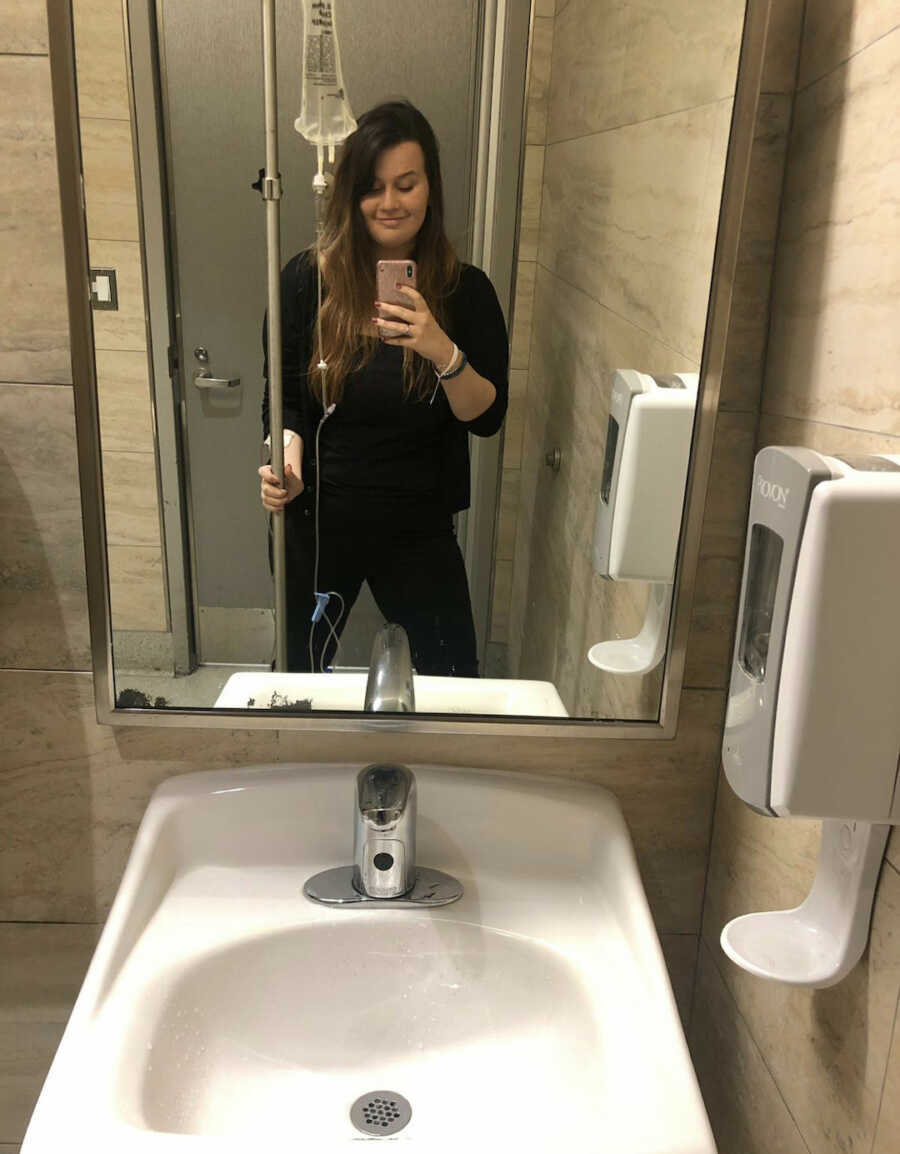 chronically ill woman with iv pole in bathroom