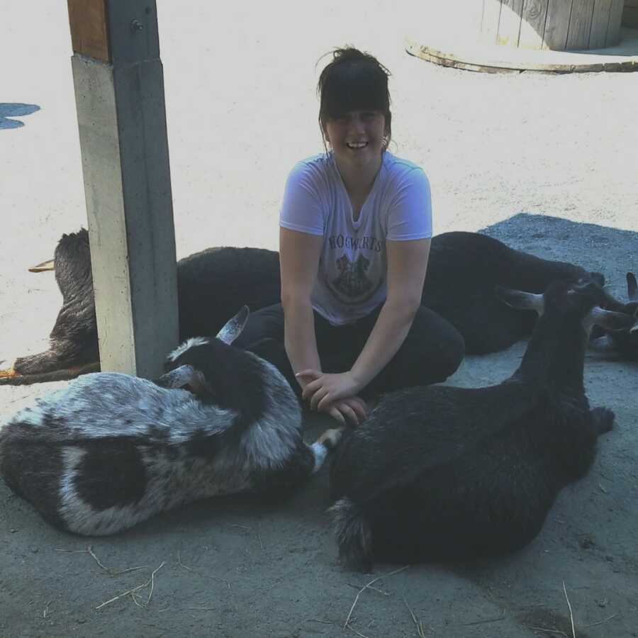 chronically ill woman sitting with goats