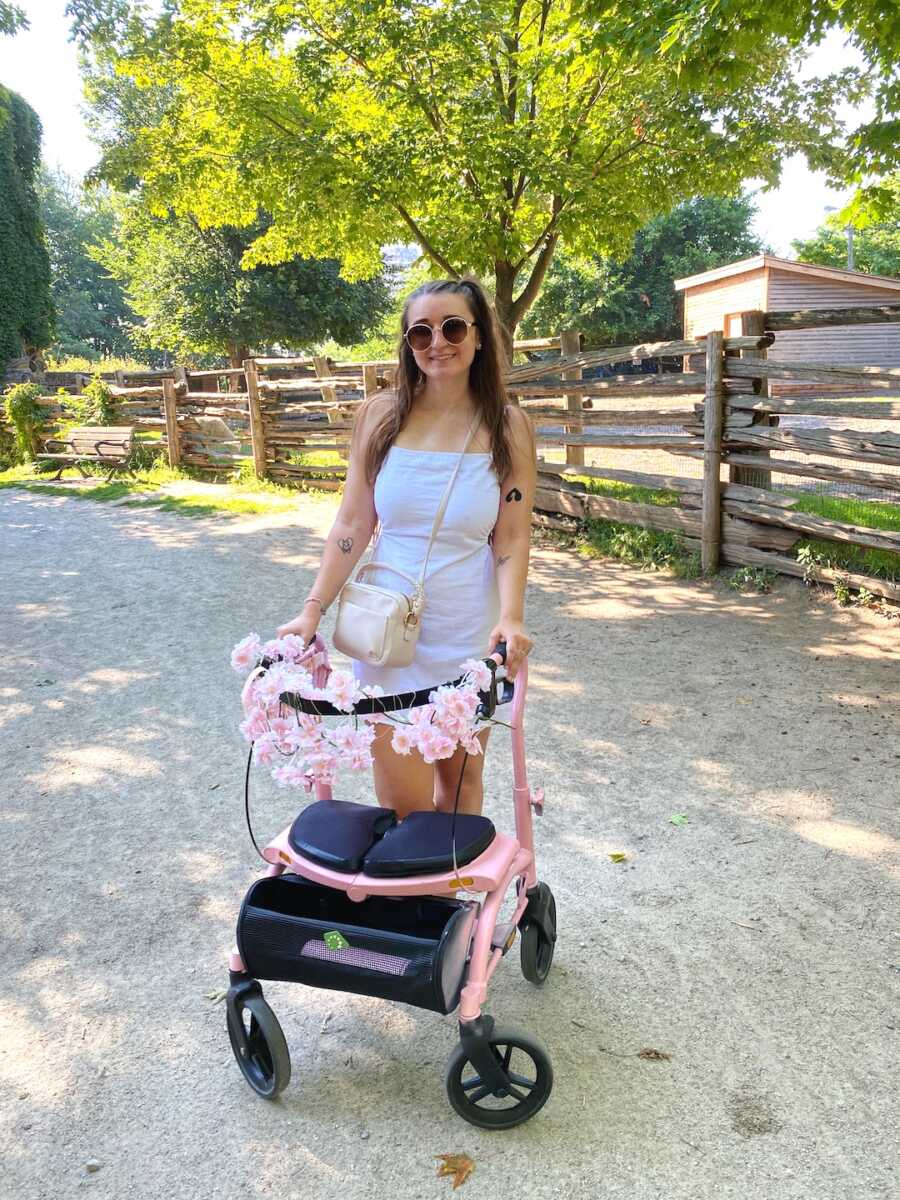 disabled woman with decorated pink walker in park