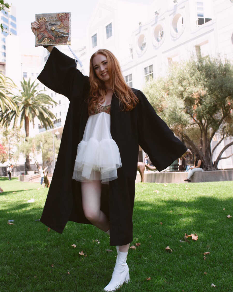 Fashion student poses in cap and gown at graduation