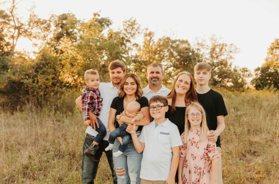 Siblings found from DNA test posing for family photo in field.