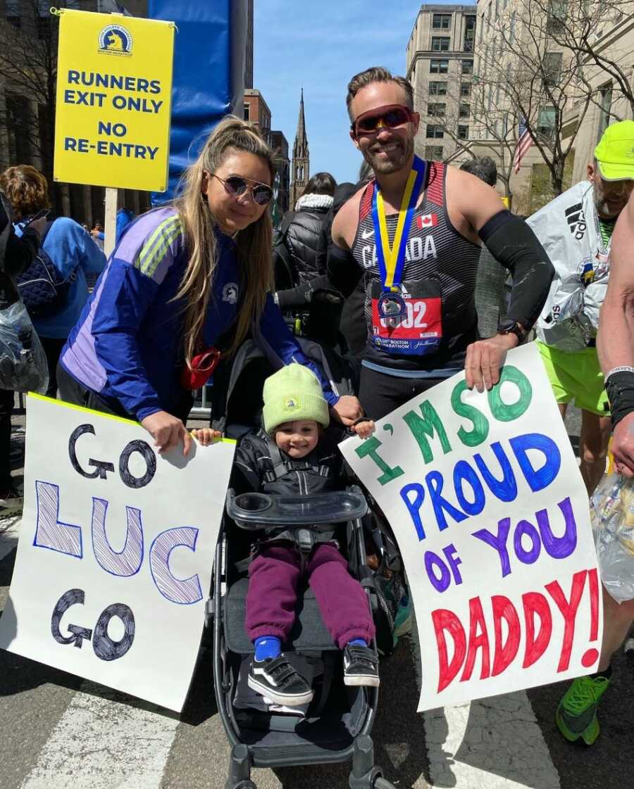 former alcoholic celebrates completing marathon with family holding encouraging signs