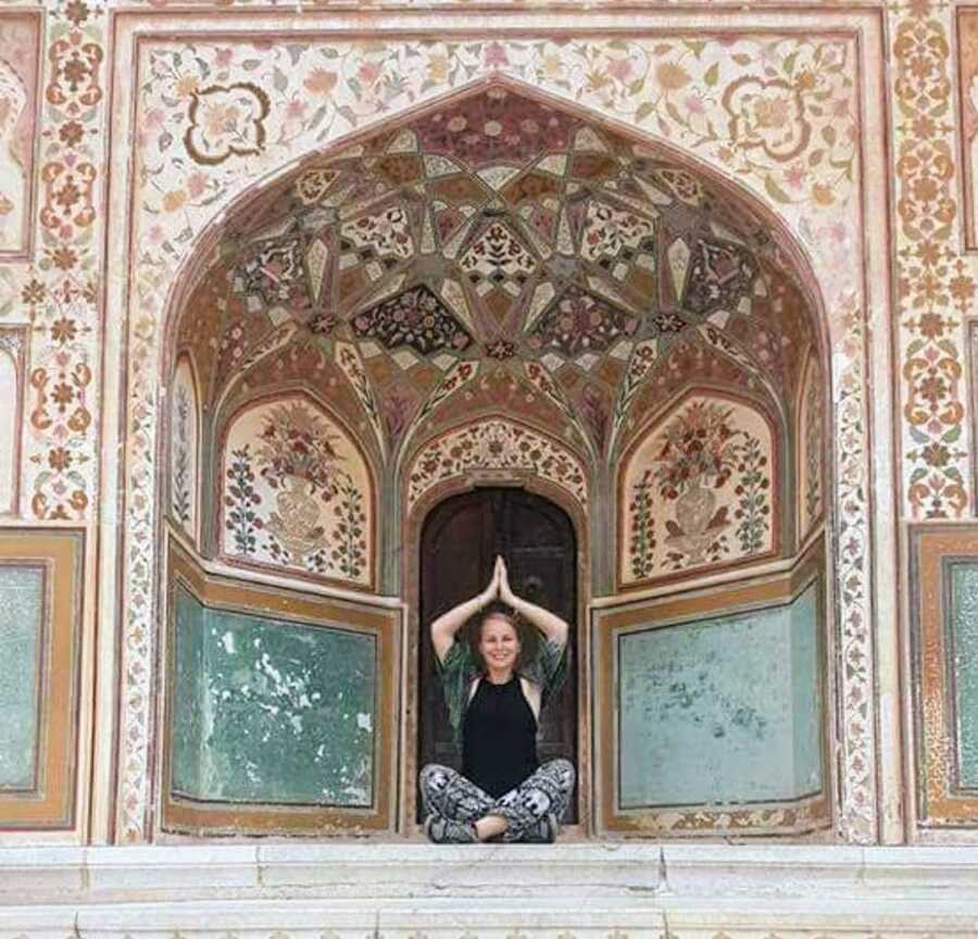 formerly abused woman meditating outside a temple