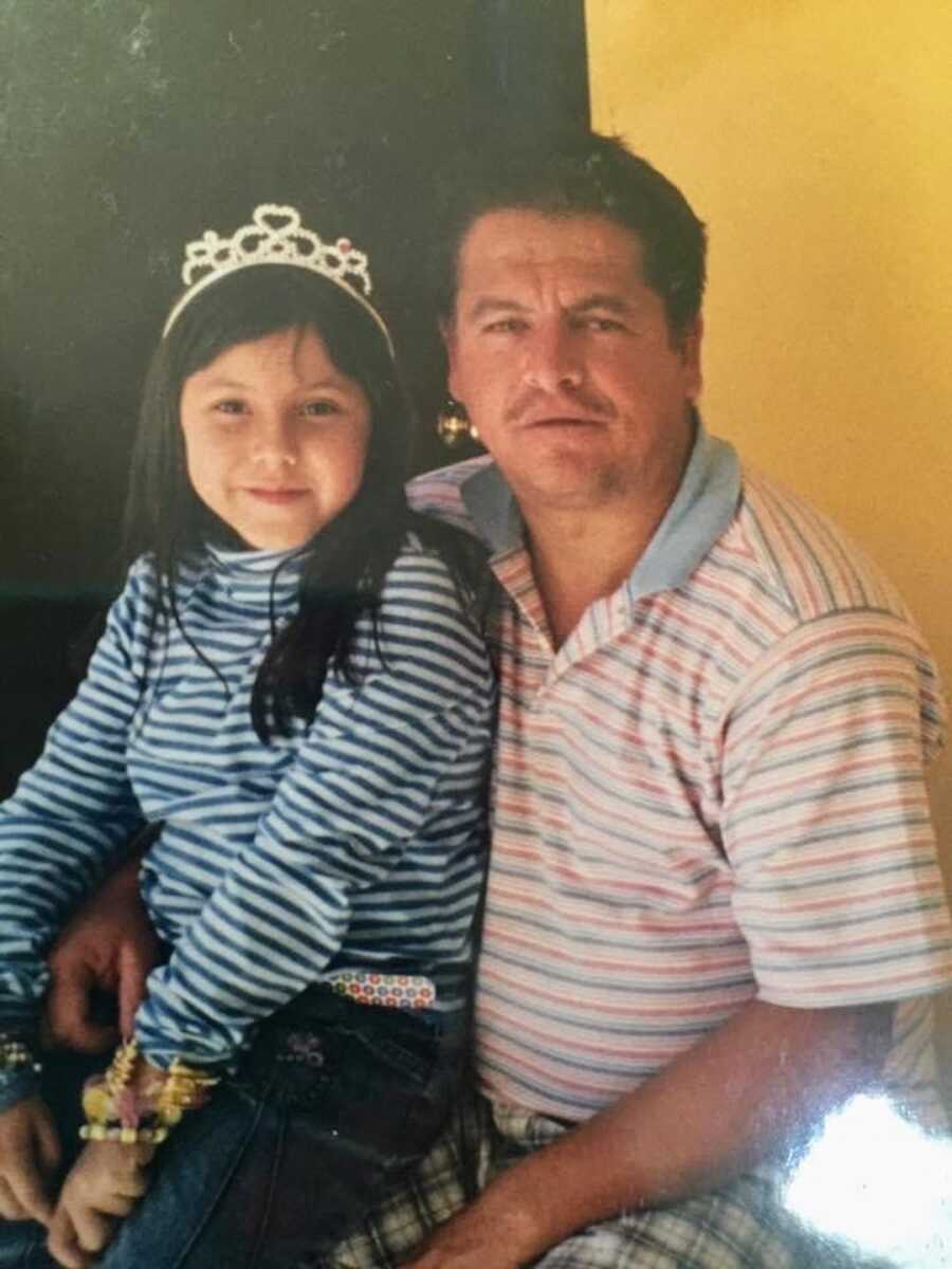 daughter with tiara sitting on her father's lap