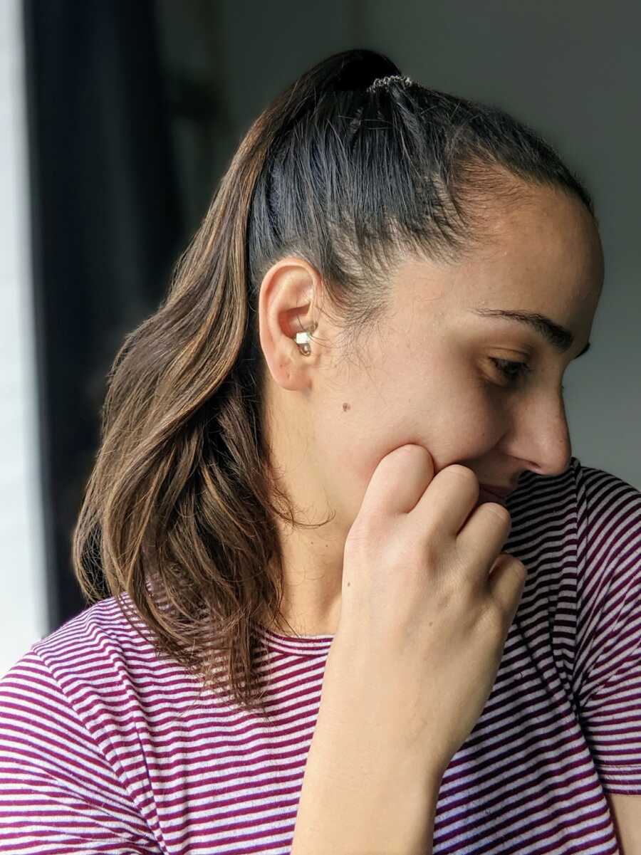 hearing disabled woman showing hearing aid in ear