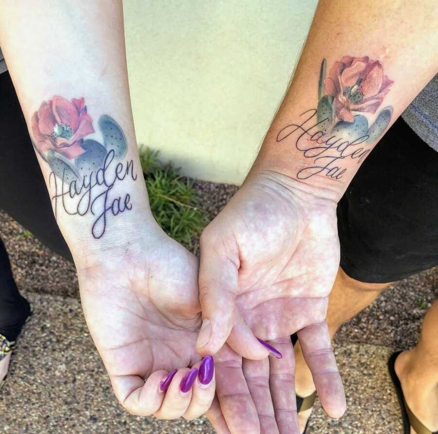 husband and wife showing matching tattoos honoring stillborn daughter