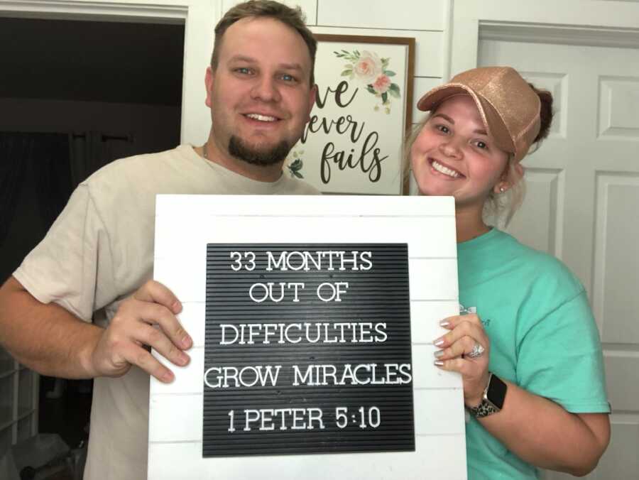 husband and wife with sign of 33 months infertility journey