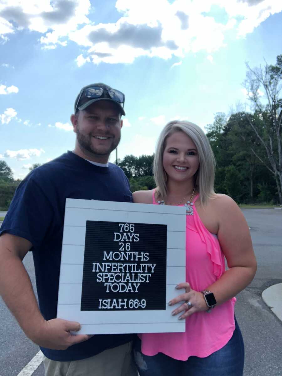 husband and wife with 765 day infertility battle sign