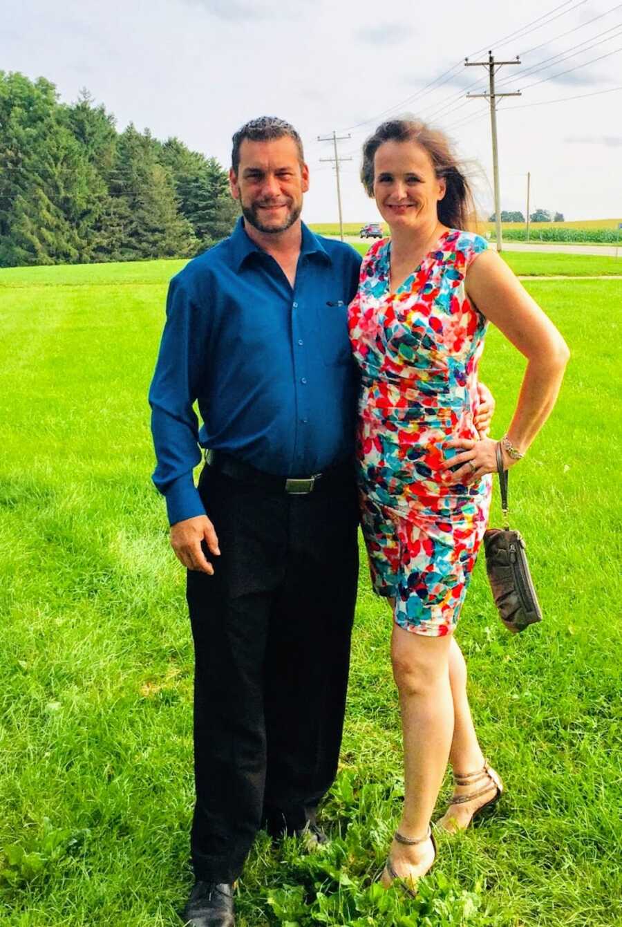 husband and wife wearing formal wear in a field
