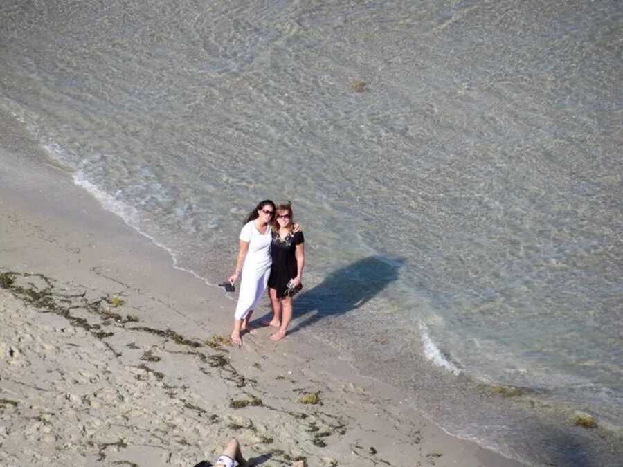 mom with daughter on the beach by the water