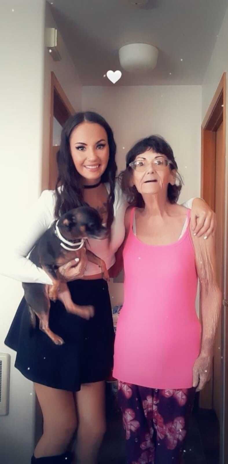 Caretaker daughter and mom stand with their dog