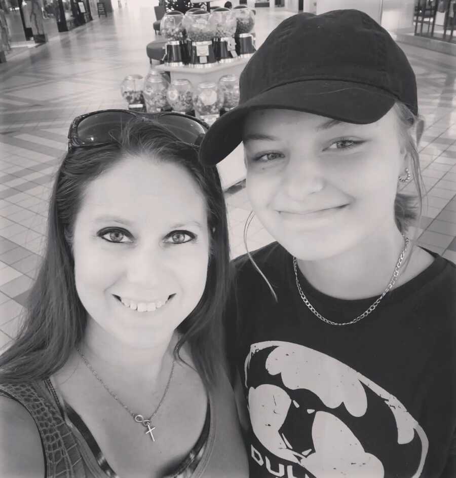 Mom and teen daughter take selfie together while shopping at the mall.