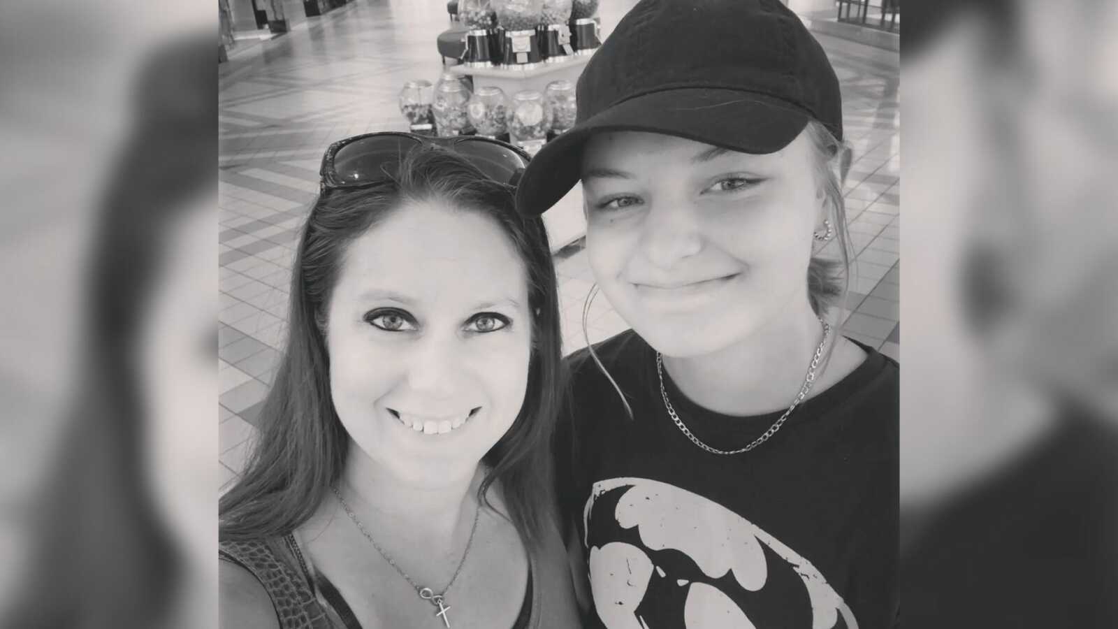 Mom and teen daughter take selfie together while shopping at the mall.