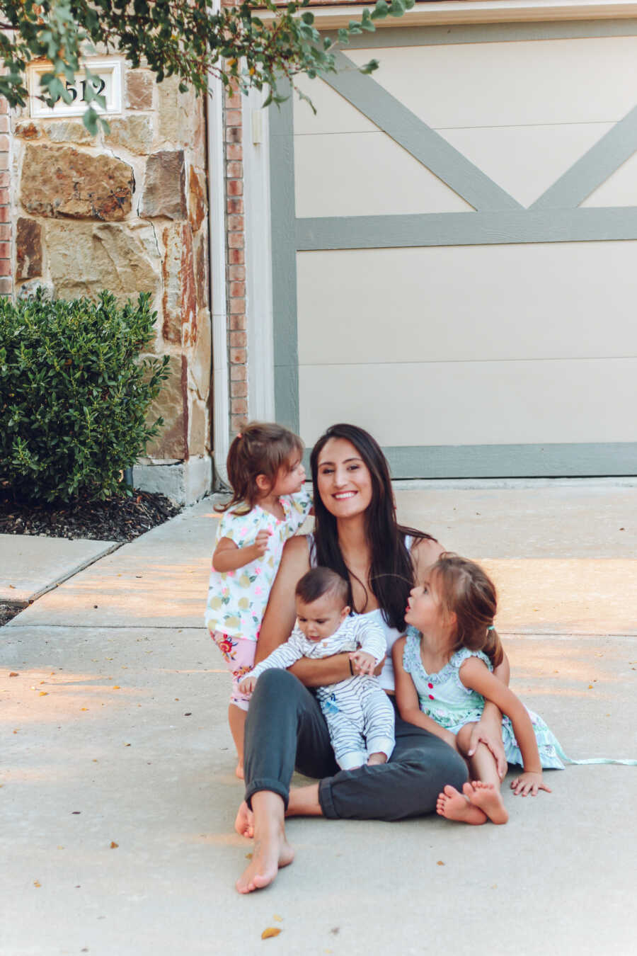 mom sits in driveway with her three children