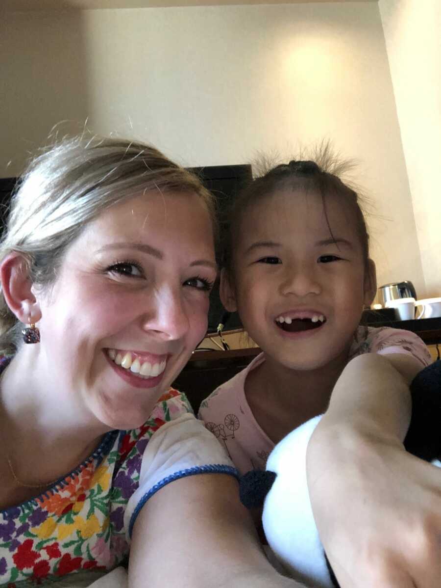 adoptive mom with internationally adopted daughter smiling at camera